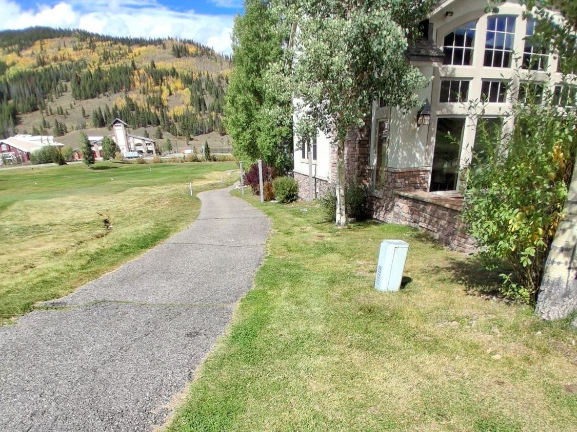 Freshly mowed lawn beside a townhome along the golf course at Copper Mountain, with fall aspens on the hillside