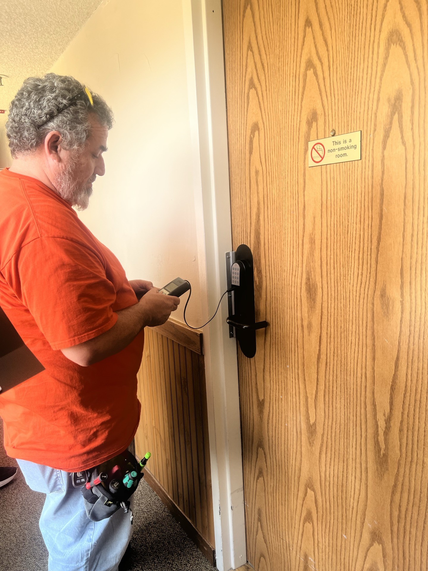 Axiom technician installing a SALTO lock on a unit door at Telemark Lodge, Copper Mountain